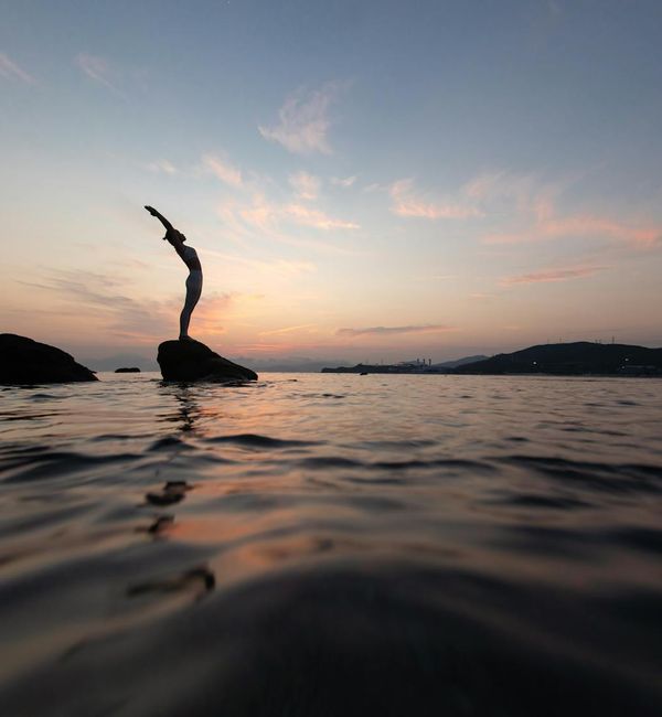 Silhouette of a person in a yoga pose against a beautiful sunset.